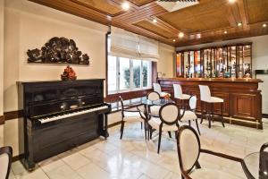 加亚新城Golden Tulip Porto Gaia Hotel的一间设有钢琴、桌子和椅子的客房