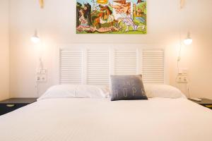圣塞瓦斯蒂安圣马西亚尔28公寓式酒店的卧室配有一张白色床,墙上挂有绘画作品