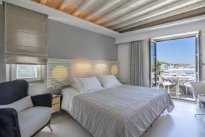 米克诺斯城Semeli Hotel Mykonos的一间带大床的卧室和一个阳台