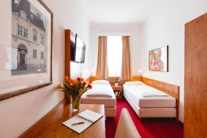 维也纳维也纳俄兰格娆酒店的酒店客房设有两张床和一张桌子。