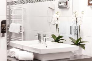 维也纳维也纳俄兰格娆酒店的白色的浴室设有水槽和毛巾。