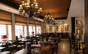 拉施塔特Hotel Zum Goldenen Mann的一间带桌椅和吊灯的餐厅