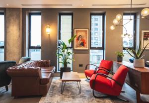 伦敦The Gate ApartHotel London的客厅配有红色椅子和沙发