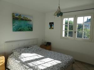 昂蒂布Villa Alessia的一间卧室设有一张床和两个窗户。