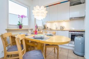 韦斯特兰Perfekte Wohnung in perfekter Lage mit Balkon!的厨房配有木桌和椅子