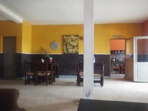 Joal-FadioutAuberge Cœur Océan的用餐室设有黄色的墙壁和桌子以及冰箱