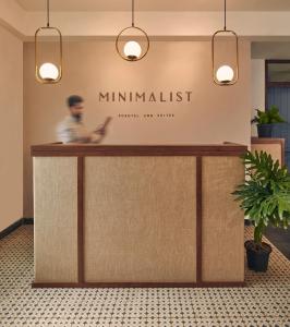 新德里Minimalist Poshtel & Suites的站在大堂柜台后面的人