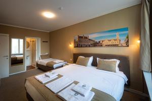 布鲁日卡瓦利酒店的酒店客房,配有两张带毛巾的床