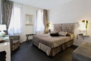 威尼斯阿尔伯格玛林酒店的配有一张床和一把椅子的酒店客房