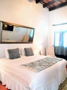 圣胡安圣胡安拉特拉扎酒店的卧室配有一张带镜子的白色大床