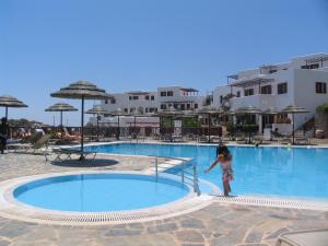 阿莫皮Aegean Village Beachfront Resort的站在游泳池前的小女孩