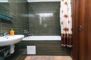 基辅Квартира на Левом берегу с видом на озеро的浴室配有盥洗盆和浴缸。