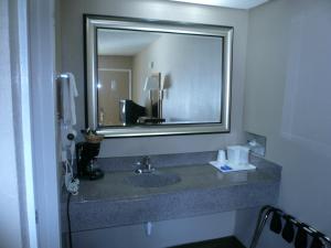 基尔戈吉尔戈行政酒店的一间带大镜子的盥洗盆的浴室