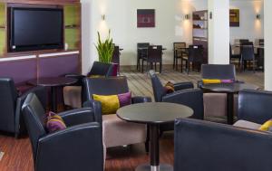 斯特灵快捷假日斯特灵酒店的一间设有桌椅和平面电视的等候室