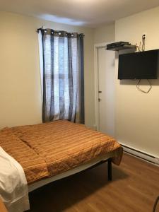 蒙特利尔旅行者之家酒店的一间卧室配有一张床和一台平面电视