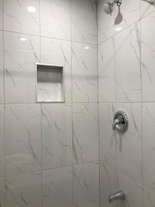 蒙特利尔旅行者之家酒店的玻璃门淋浴和银色淋浴头