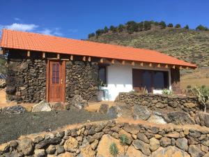 El Pinar del HierroCasa Rural Los Santillos的一座带橙色屋顶的小石头房子