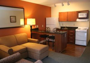 费耶特维尔Affordable Suites - Fayetteville/Fort Bragg的带沙发的客厅和厨房