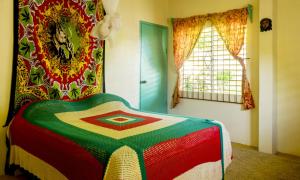 Manchioneal锡安乡村住宿加早餐旅馆的卧室配有色彩缤纷的毯子