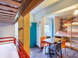 费内-伏尔泰hotelF1 Genève Aéroport Ferney的小房间设有桌椅和一张双层床