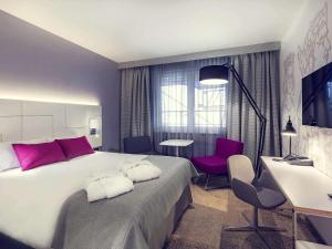 克拉科夫克拉科夫旧城区美居酒店的一间卧室配有一张大床和一张桌子及椅子
