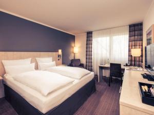 比勒费尔德比尔费尔德约翰尼斯堡美居酒店的酒店客房设有一张大床和一张书桌。