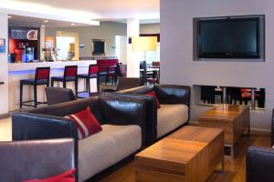 特伦特河畔斯托克快捷假日特伦特河畔斯多克酒店的带沙发的客厅和带电视的酒吧