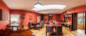 皮萨克Pisac Inn的一间拥有红色墙壁和木桌及椅子的用餐室
