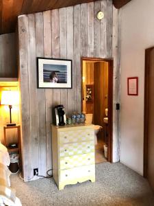 GabriolaThe Surf Lodge and Pub的一间卧室设有木墙、梳妆台和一张照片