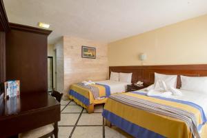 梅里达梅里达大使酒店的酒店客房配有两张床和一张书桌