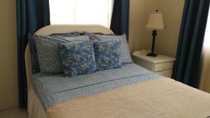 基督教堂市JersonApartments的一间卧室配有一张带蓝色枕头的床和一扇窗户。