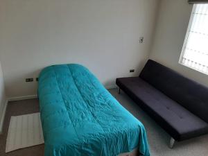 巴拉斯港Quimantu的一间卧室配有蓝色的床和沙发