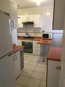 巴拉斯港Quimantu的厨房配有白色橱柜和台面