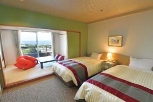 神户The Gran Resort Princess Arima的酒店客房设有两张床和窗户。