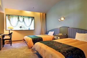 神户The Gran Resort Princess Arima的酒店客房配有两张床和一张书桌