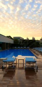 新加坡新加坡凱煌大酒店的两张桌子和一个游泳池,位于一座天空建筑中
