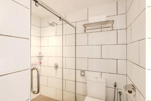 塞贝维FOX Lite DPulze Cyberjaya by Ascott的白色瓷砖浴室设有卫生间和淋浴。