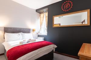 因弗内斯Bazpackers的一间卧室配有一张带红色毯子和镜子的床