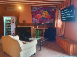 埃尔罗西奥Alojamiento Rural Flamingo的客厅配有两把椅子和壁炉