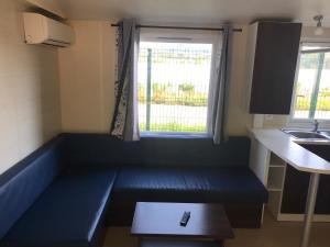 普拉加德阿罗Camping Castell D'aro的小房间,厨房里设有蓝色长椅