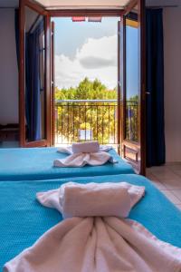干尼亚Poco Loco Bed & Breakfast的一间卧室设有一张蓝色的床和大窗户