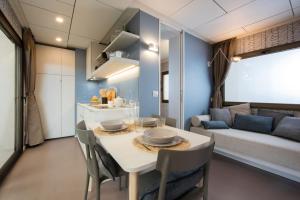 康特港Villaggio Camping Torre Del Porticciolo的厨房以及带桌椅的起居室。