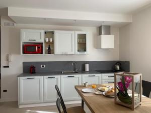 阿科阿科度假公寓的厨房配有白色橱柜和木桌