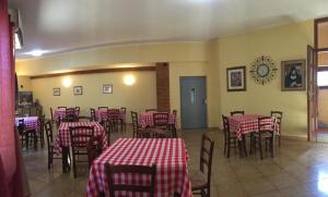 多尔加利Hotel Sant'elene的餐厅设有红色和白色的桌椅