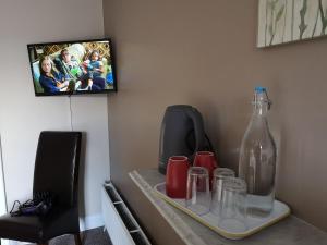 多尼戈尔O'Donnell's Of Donegal的一张桌子,上面放有瓶子和杯子,还有一台电视
