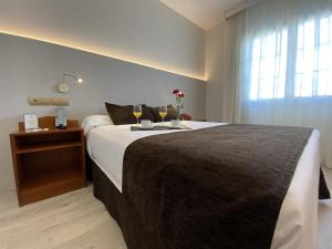 蓬费拉达庞费拉达广场酒店的一间卧室设有一张大床和一个窗户。