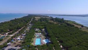 奥尔贝泰洛Orbetello Family Camping Village的享有带游泳池和海洋的度假村的空中景致