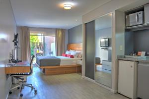 蒙得维的亚兰布拉皇家设计公寓酒店的一间卧室配有一张床和一张桌子及椅子