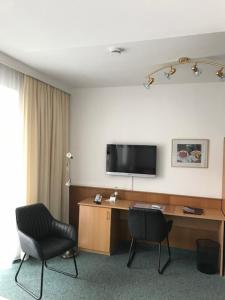 慕尼黑Hotel Occam的客房设有一张桌子、一台电视和两把椅子