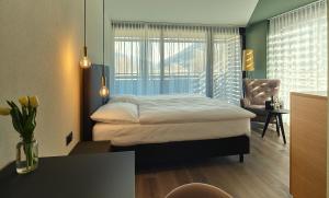 苏斯坦Links Leuk Golfresort的一间卧室配有一张床、一张书桌和一个窗户。